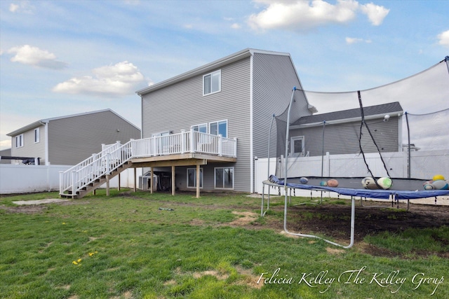 560 Pioneer Trl, Cedar Springs, MI 49319 - back of house featuring stairs, a trampoline, fence, a yard, and a wooden deck