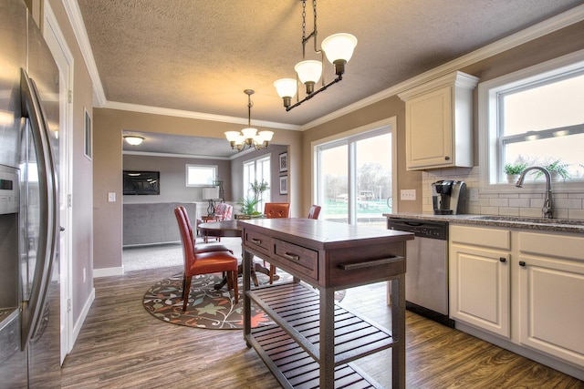 5672 Landrum Trl, Portage, MI 49024 - kitchen with appliances with stainless steel finishes, a sink, dark wood-style flooring, a chandelier, and ornamental molding