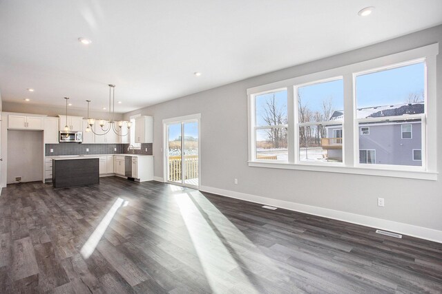 8851 Loggers Ridge Ct SE, Caledonia, MI 49316 - unfurnished living room with dark wood-style flooring, baseboards, visible vents, and recessed lighting