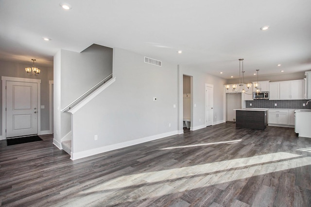 8851 Loggers Ridge Ct SE, Caledonia, MI 49316 - kitchen featuring dark wood-style flooring, a chandelier, visible vents, and stainless steel microwave