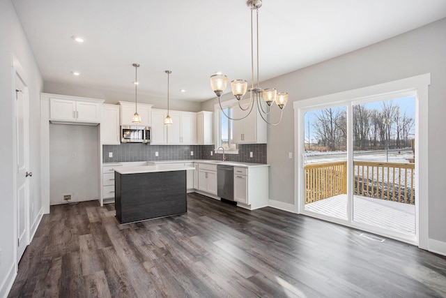 8851 Loggers Ridge Ct SE, Caledonia, MI 49316 - kitchen featuring a sink, stainless steel appliances, white cabinets, dark wood finished floors, and backsplash