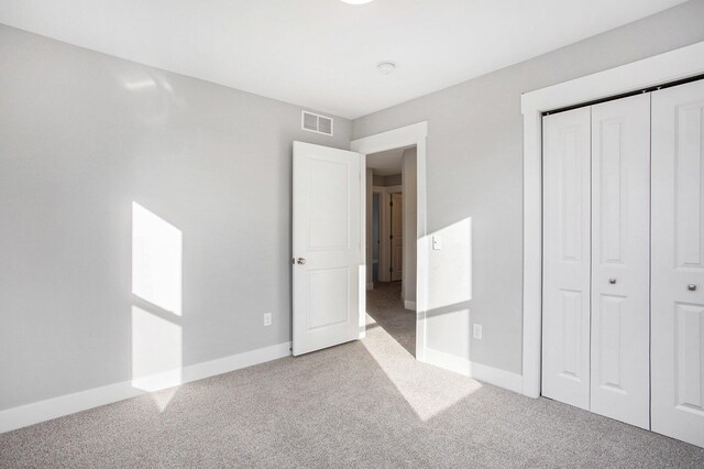 8851 Loggers Ridge Ct SE, Caledonia, MI 49316 - unfurnished bedroom with carpet, visible vents, baseboards, and a closet