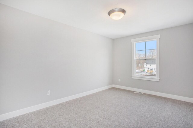 8851 Loggers Ridge Ct SE, Caledonia, MI 49316 - spare room with light carpet, baseboards, and visible vents