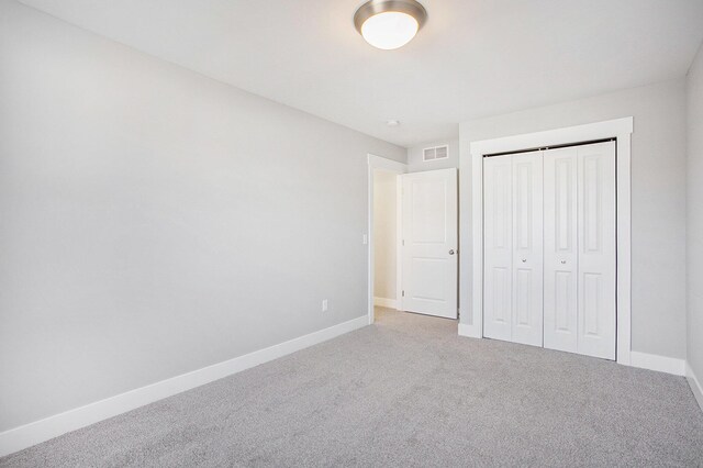 8851 Loggers Ridge Ct SE, Caledonia, MI 49316 - unfurnished bedroom with carpet floors, baseboards, visible vents, and a closet