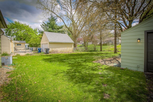 view of yard featuring an outdoor structure, a detached garage, and fence