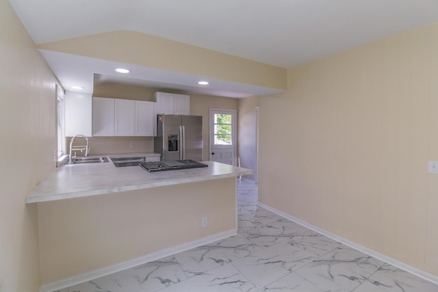 kitchen with a sink, a peninsula, stainless steel fridge with ice dispenser, and marble finish floor