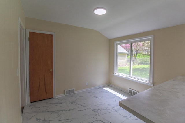 unfurnished dining area featuring vaulted ceiling, visible vents, marble finish floor, and baseboards