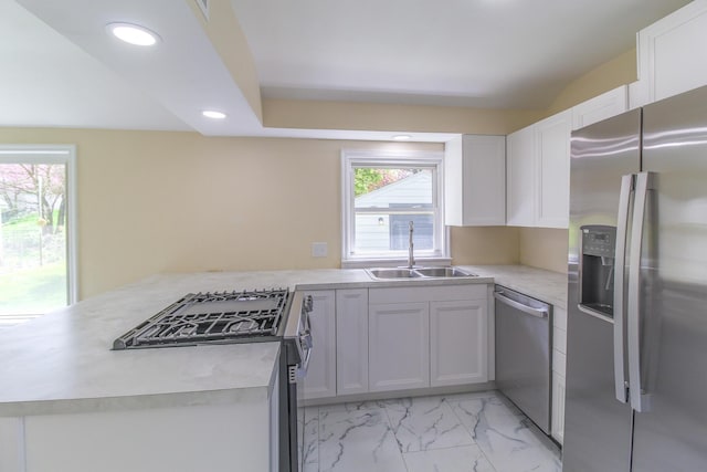 kitchen with recessed lighting, a sink, white cabinetry, light countertops, and appliances with stainless steel finishes