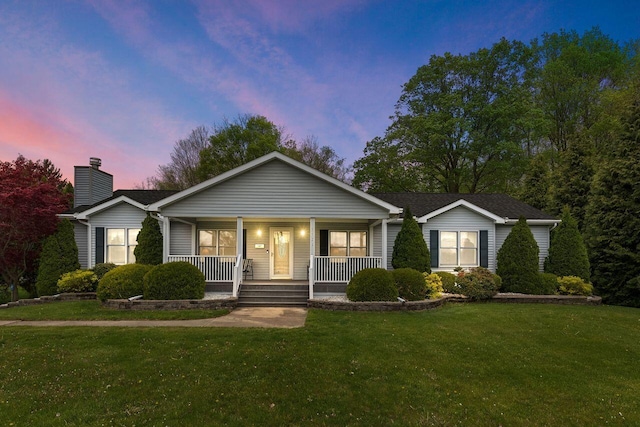 5521 W Spring Creek Rd, Three Oaks, MI 49128 - view of front facade with a porch, a chimney, and a front lawn