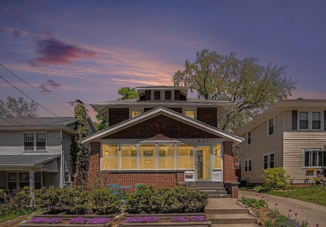 american foursquare style home featuring brick siding
