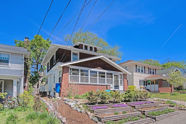 back of house with a vegetable garden and brick siding