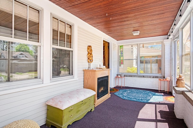 sunroom featuring a lit fireplace