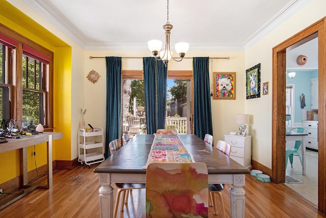 dining room featuring a chandelier, wood finished floors, baseboards, and ornamental molding