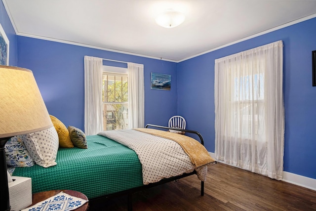 bedroom featuring wood finished floors, baseboards, and ornamental molding