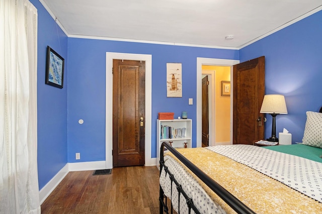 bedroom featuring dark wood finished floors, baseboards, and crown molding