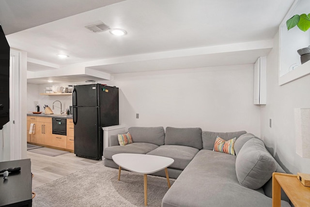 living area featuring light wood-type flooring, bar with sink, and recessed lighting