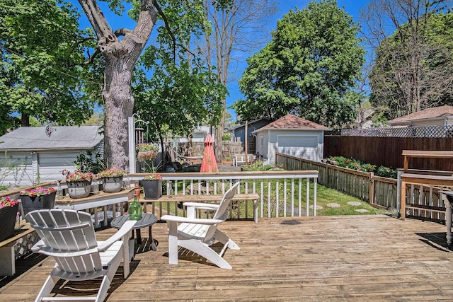 wooden deck with a fenced backyard and a detached garage
