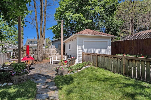 view of yard featuring a garage, an outdoor structure, and a patio area