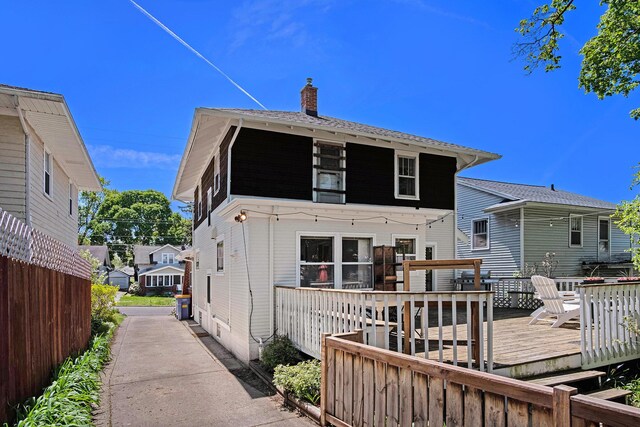 rear view of property featuring a deck and a chimney