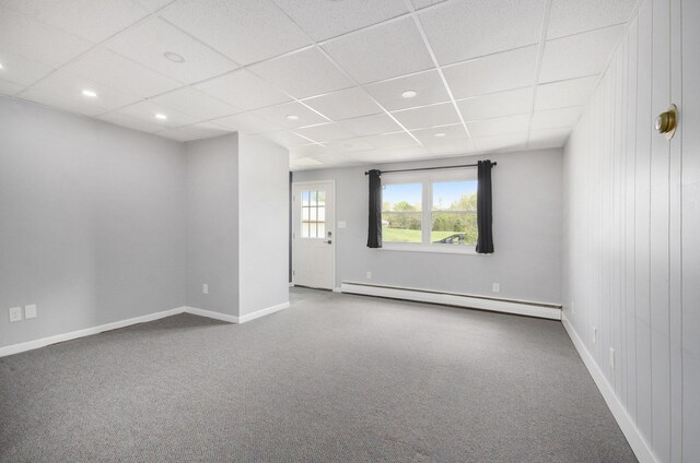 carpeted spare room featuring a baseboard heating unit, baseboards, a drop ceiling, and recessed lighting