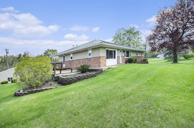 view of side of home with brick siding and a yard