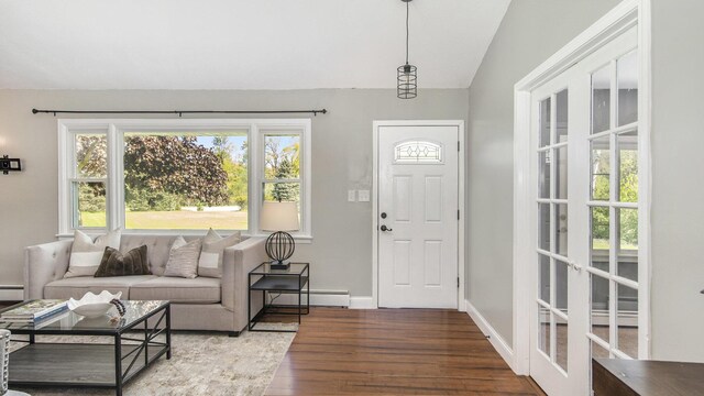 foyer entrance featuring wood finished floors, a baseboard heating unit, lofted ceiling, and baseboards
