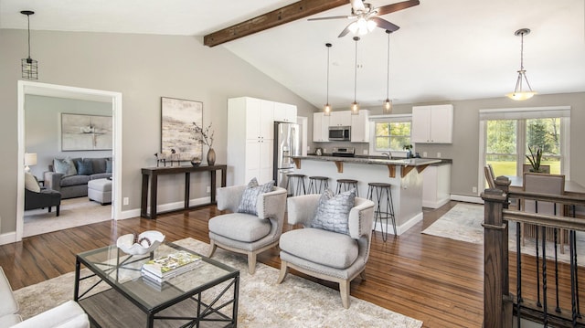 living room with a ceiling fan, a baseboard heating unit, wood finished floors, and baseboards