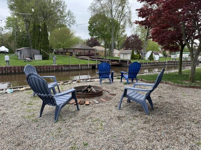 view of yard featuring an outdoor fire pit and a water view