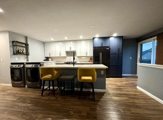 kitchen with washer and clothes dryer, black fridge, baseboards, white cabinetry, and recessed lighting