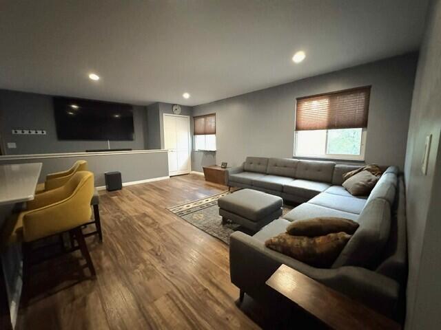 living area with wood finished floors, plenty of natural light, and recessed lighting