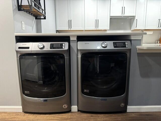 laundry room with washer and dryer, baseboards, wood finished floors, and cabinet space