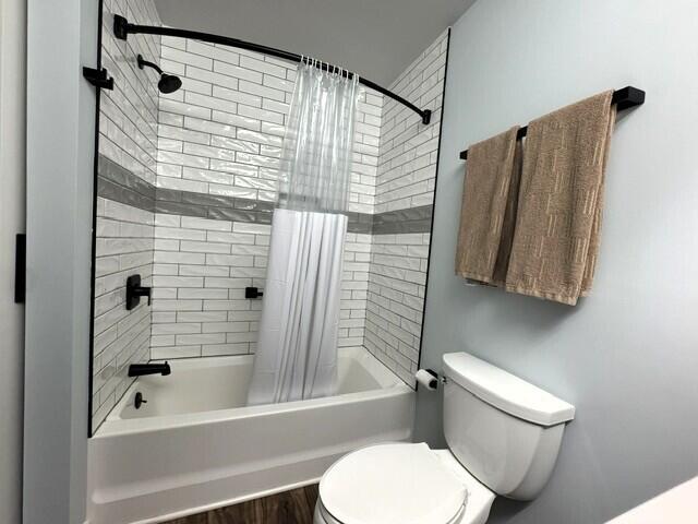 full bathroom featuring shower / tub combo and toilet
