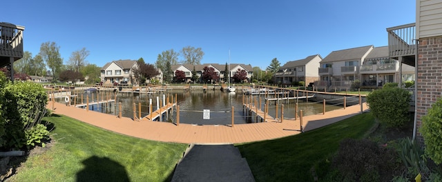 dock with a residential view, a yard, and a water view