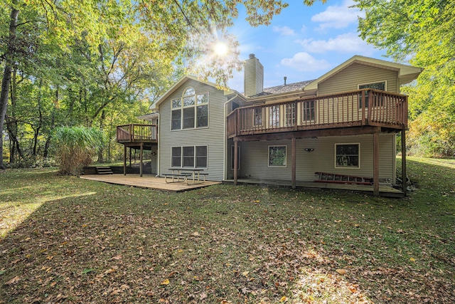 back of property featuring a lawn, a patio, a chimney, and a wooden deck