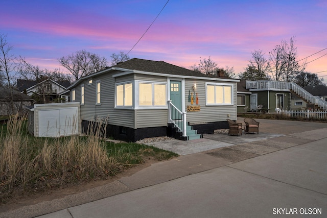 1520 Beach St, Muskegon, MI 49441 - view of front of property featuring entry steps, a patio area, and a chimney