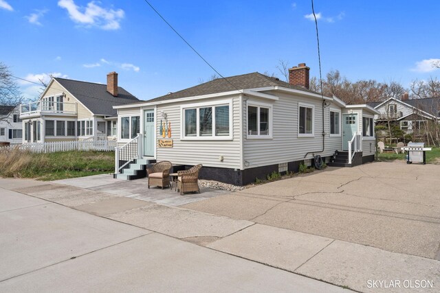 1520 Beach St, Muskegon, MI 49441 - back of property with entry steps and a chimney