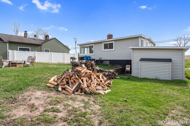 1520 Beach St, Muskegon, MI 49441 - back of house featuring an outdoor fire pit, a chimney, and a garage