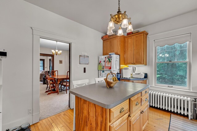 2486 Whitmore Lake Rd, Ann Arbor, MI 48105 - kitchen with radiator, a chandelier, freestanding refrigerator, dark countertops, and light wood-style flooring