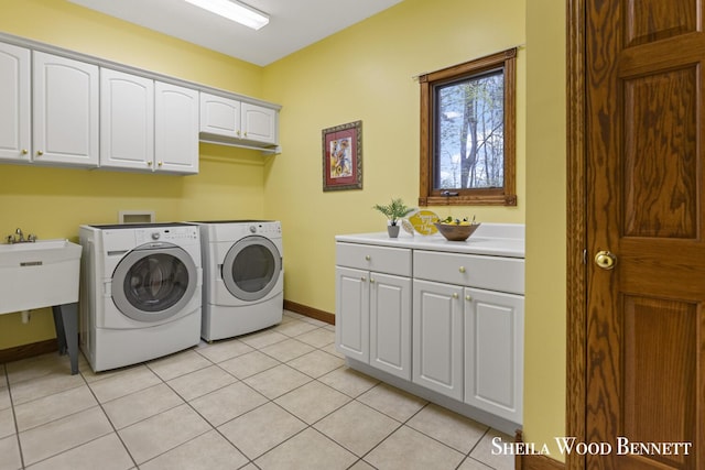 903 10 Mile Rd NW, Sparta, MI 49345 - washroom featuring cabinet space, washing machine and clothes dryer, baseboards, and light tile patterned floors