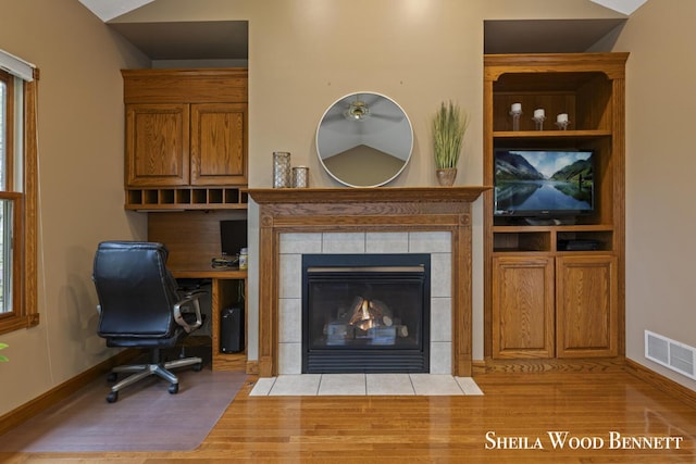 903 10 Mile Rd NW, Sparta, MI 49345 - office space featuring wood finished floors, baseboards, vaulted ceiling, and a tiled fireplace