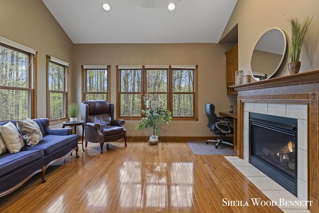 903 10 Mile Rd NW, Sparta, MI 49345 - living room with healthy amount of natural light, vaulted ceiling, light wood-style flooring, a tile fireplace, and recessed lighting