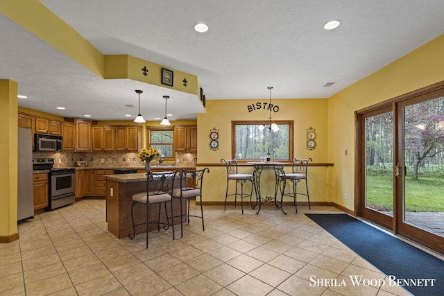 903 10 Mile Rd NW, Sparta, MI 49345 - kitchen featuring stainless steel appliances, brown cabinets, decorative backsplash, light tile patterned flooring, and recessed lighting