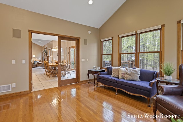 903 10 Mile Rd NW, Sparta, MI 49345 - living area featuring baseboards, healthy amount of natural light, light wood-style flooring, and high vaulted ceiling
