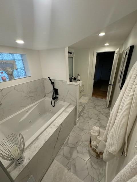 819 W Michigan St, New Buffalo, MI 49117 - bathroom featuring marble look tiles, a tub with jets, and recessed lighting