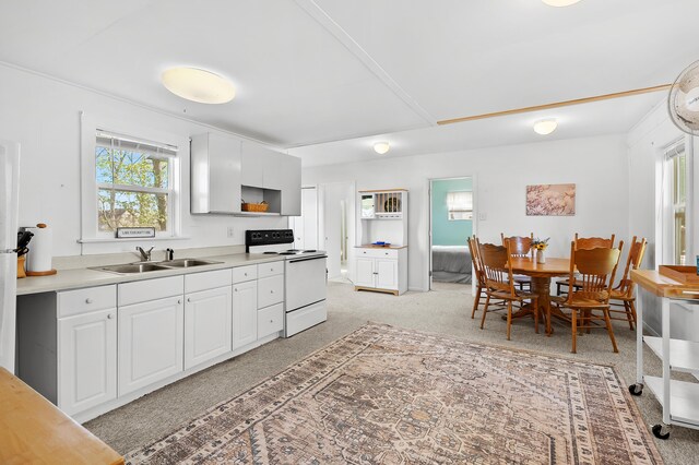10982 Beech Is, Plainwell, MI 49080 - kitchen with white range with electric cooktop, a sink, light countertops, white cabinets, and light colored carpet
