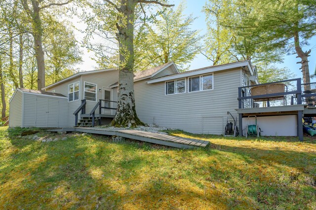 10982 Beech Is, Plainwell, MI 49080 - rear view of house with a deck, a yard, a storage unit, and an outbuilding