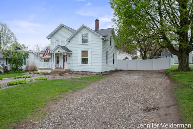 victorian-style house featuring dirt driveway and a chimney