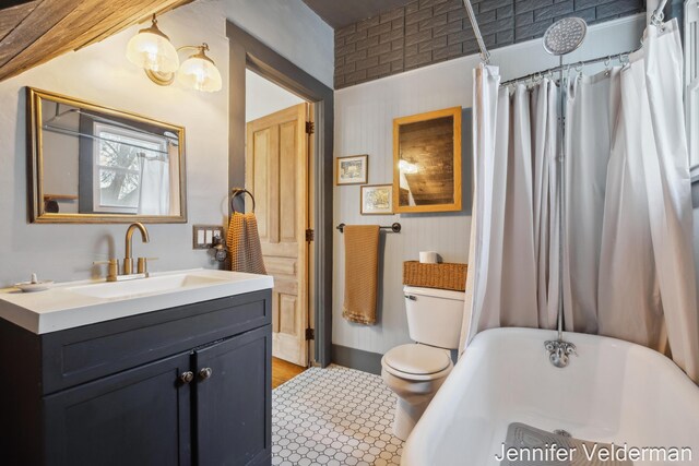 full bathroom with a freestanding bath, toilet, and vanity