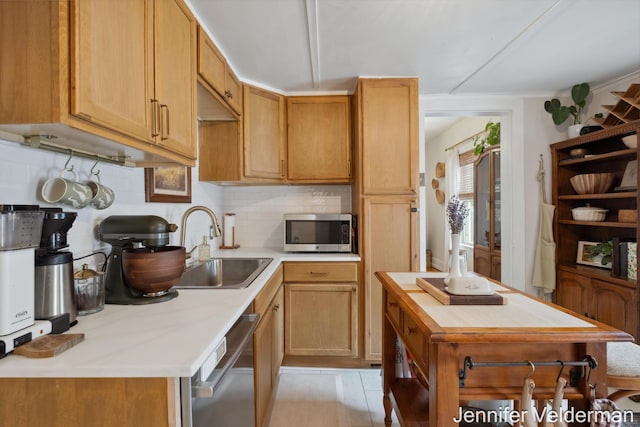 kitchen with stainless steel appliances, a sink, backsplash, and a kitchen island