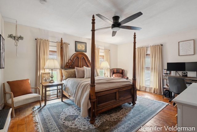 bedroom featuring multiple windows, hardwood / wood-style floors, and an office area